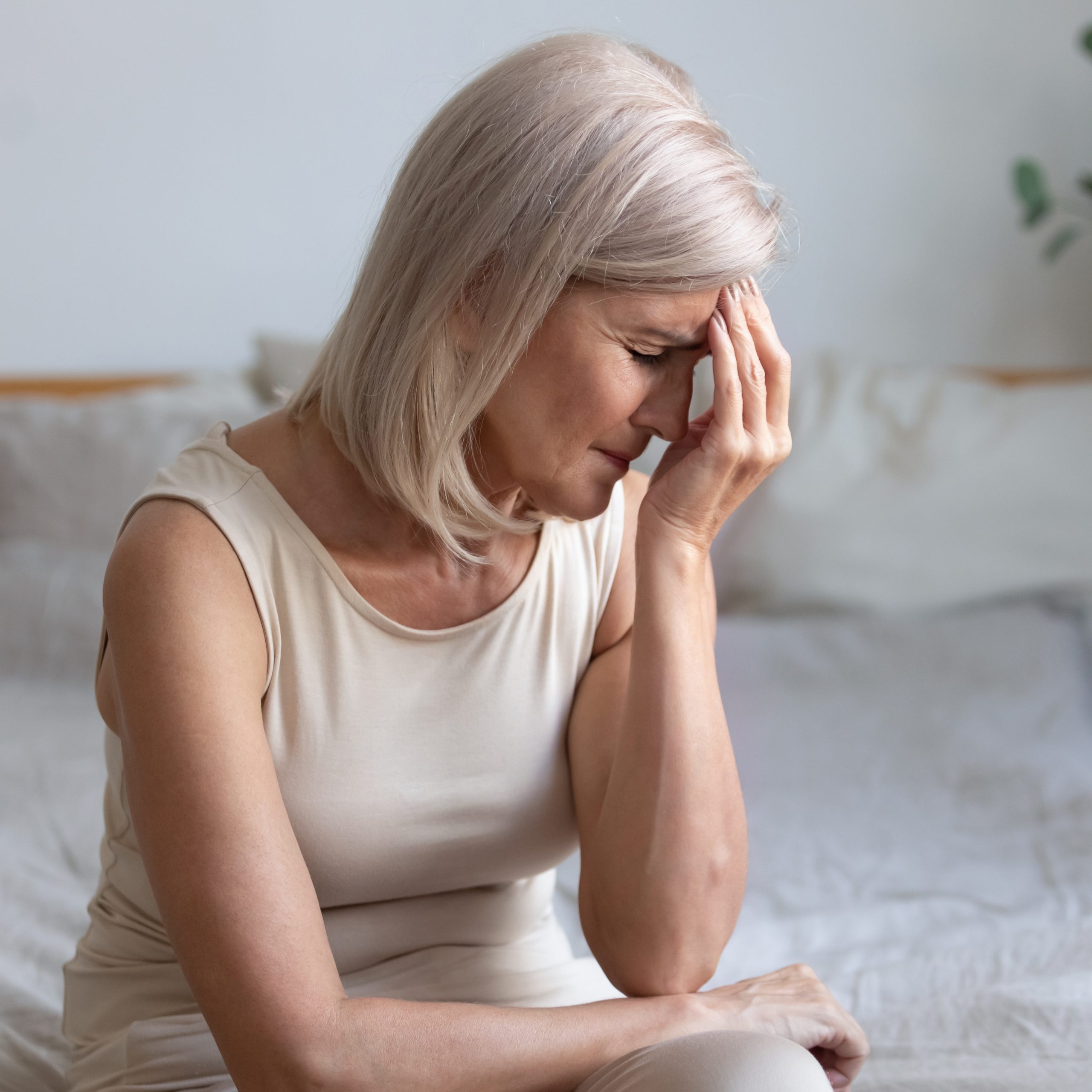 senior woman holding forehead