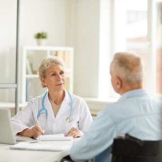 Portrait of female doctor consulting senior man sitting at desk in office, copy space